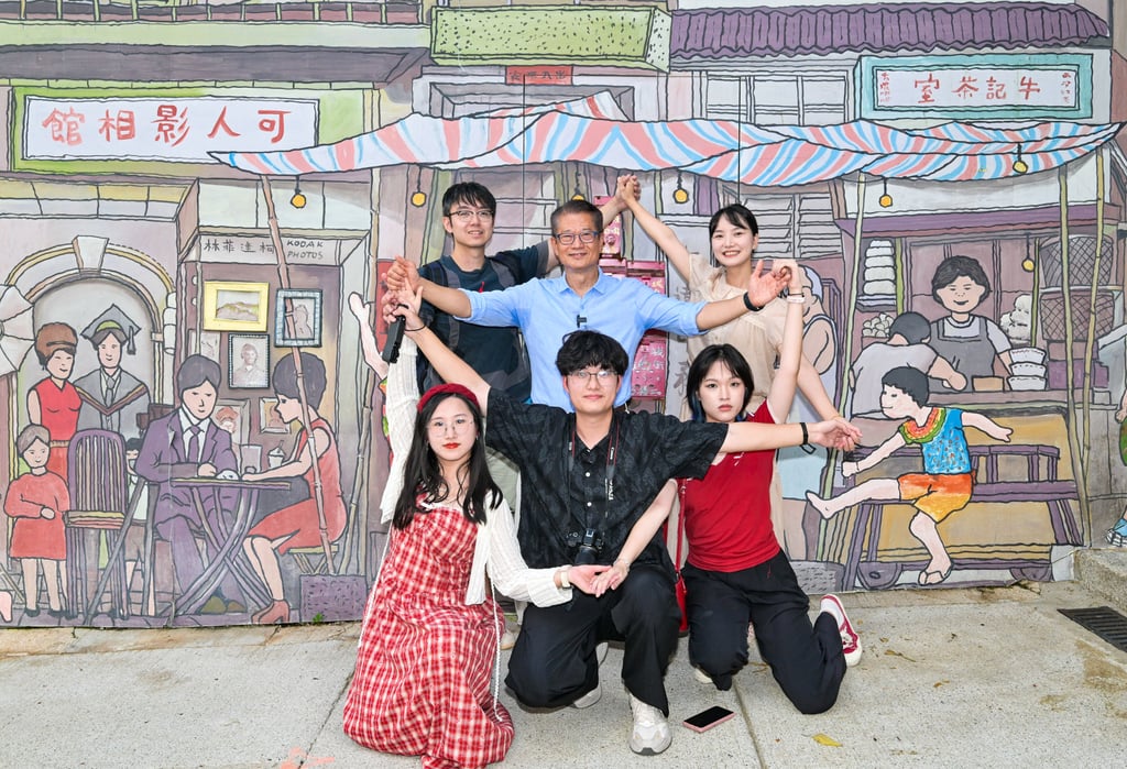 Finance chief Paul Chan poses for a photo with tourists. Photo: Handout