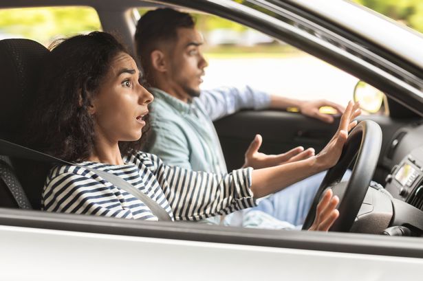 Stunned young woman driver looking at road with shocked face expression