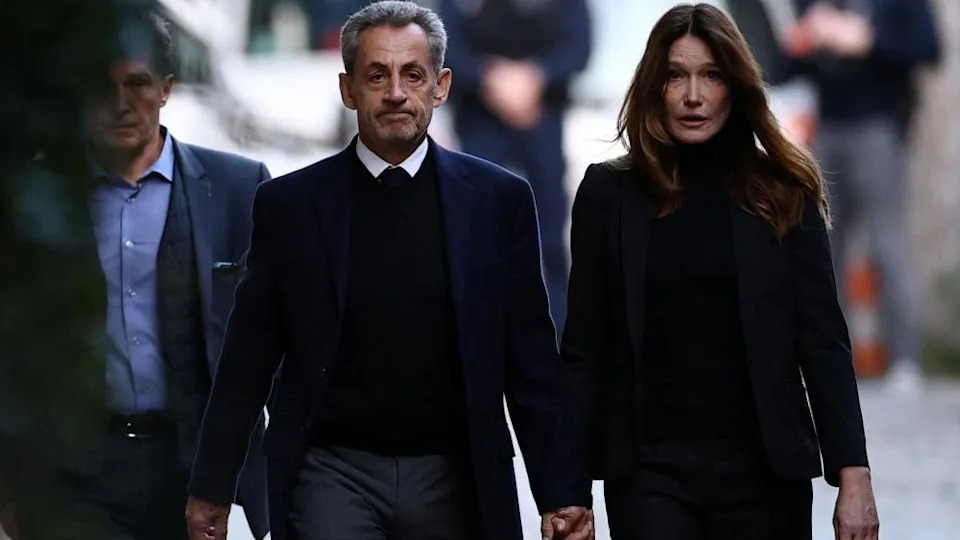 Former French President Nicolas Sarkozy leaves his house with his wife Carla Bruni-Sarkozy on the day of his incarceration at the Sante prison to begin his five-year prison sentence for criminal conspiracy over attempts to raise campaign funds from Libya, in Paris, France, October 21, 2025.