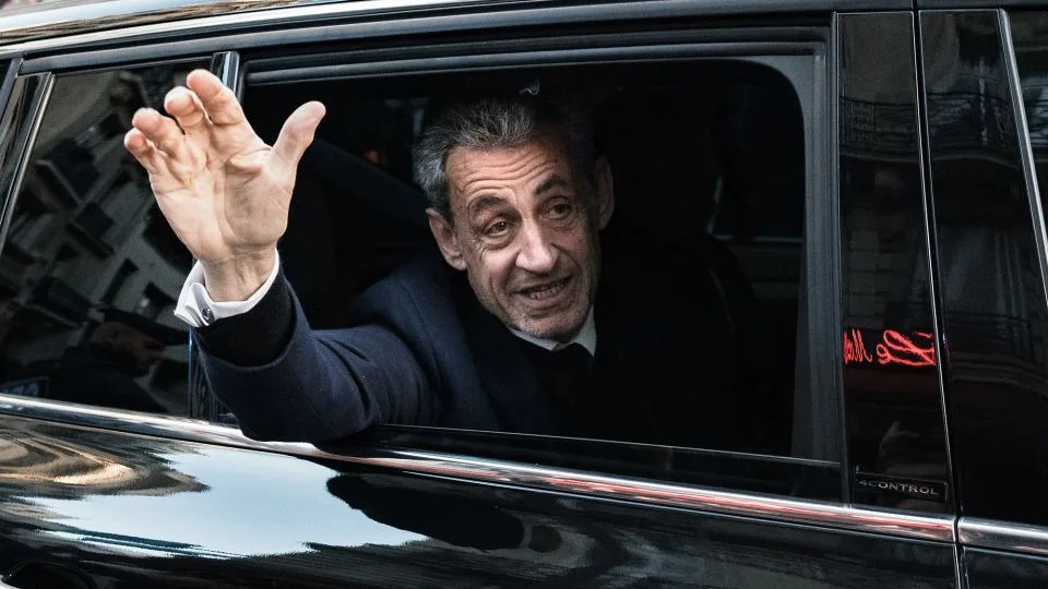 France's former president Nicolas Sarkozy waves to his supporters as he leaves his residence for prison on Tuesday. - Jerome Gilles/NurPhoto/Getty Images