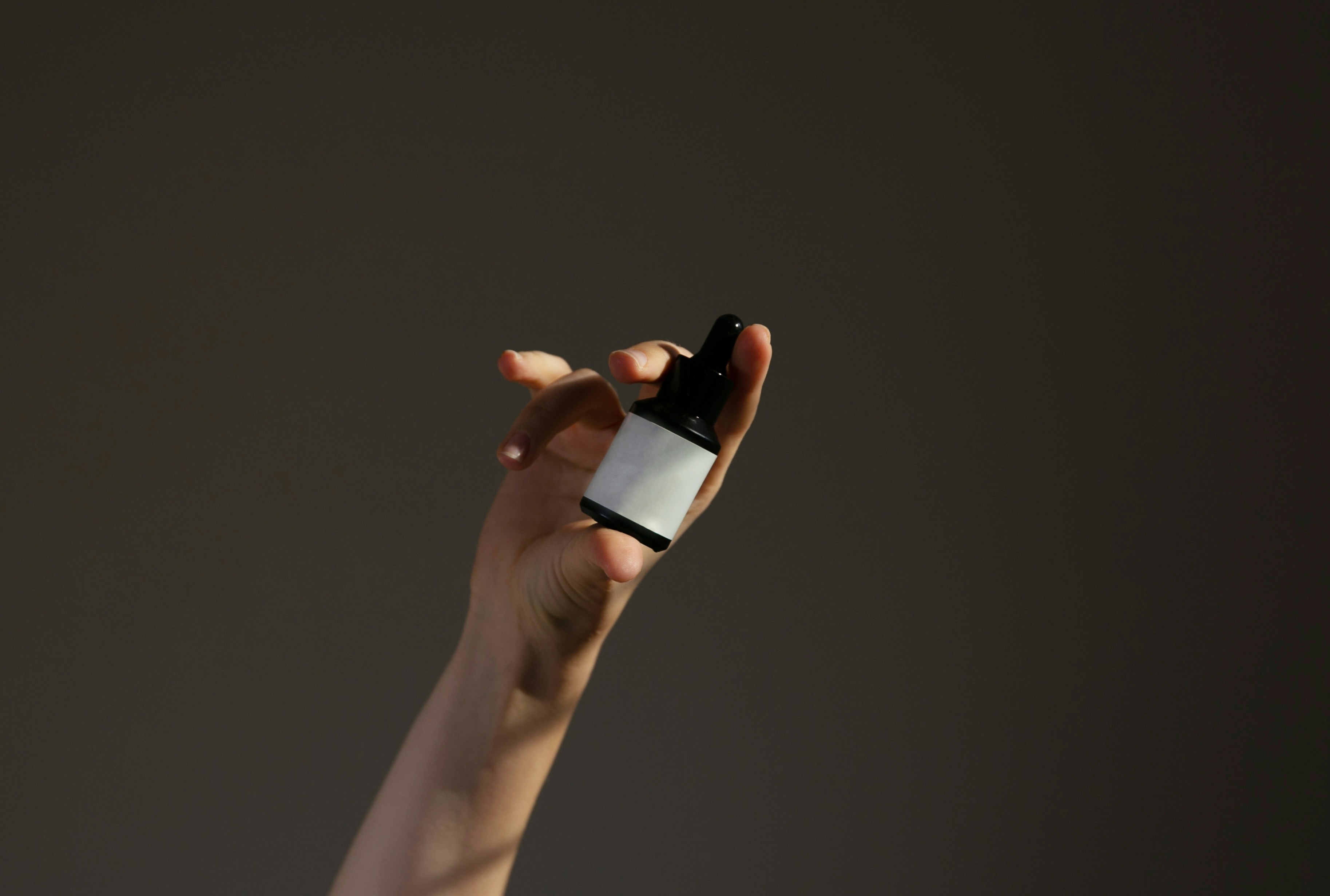 A hand holding a serum.