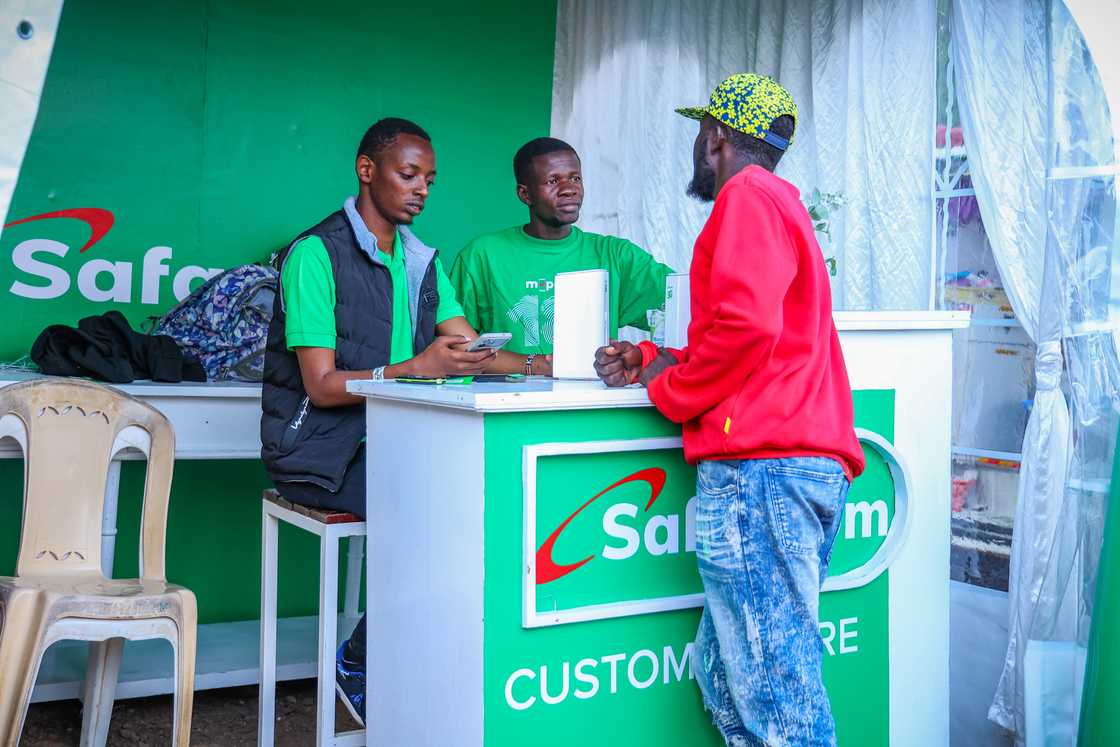 Safaricom officials with a customer.