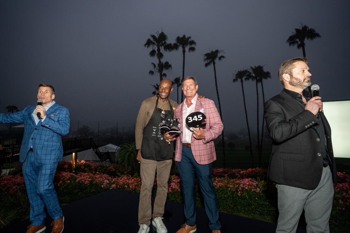 Jerry Rice, center left, stands with winning auction bidder Bryan Zatica at the Athletes First Celebrity Waiter Night.
