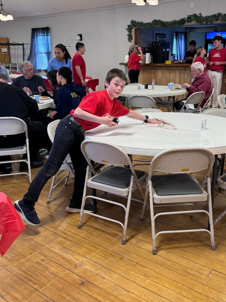 Lucas Mullen cleans a table. 