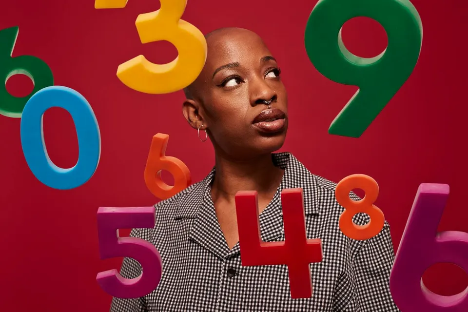 Non-binary person looking at various numbers